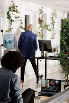 Project manager discussing team performance with executive during videocall on laptop screen. Business employee talking with startup entrepreneur in online meeting in office