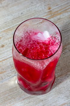 Pink gin cocktail with red blood orange and ice. An alcoholic, refreshing drink.