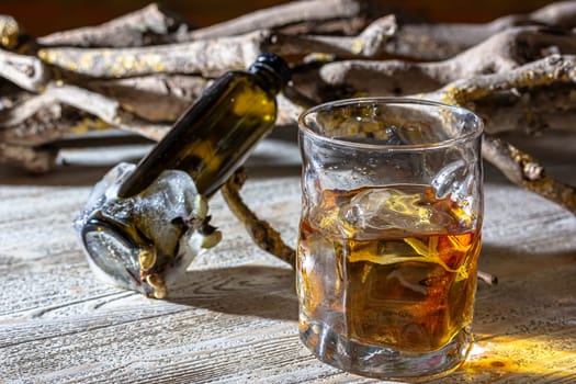 сognac or brandy into a glass against the backdrop of nature trees and sunset. firewood moss nature. wood. evening drinking in nature. close up