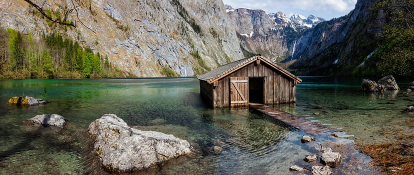 Panorama of Obersee mountain lake with boat dock hangar in Alps. Bavaria, Germany