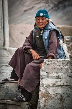 LAMAYURU, INDIA - SEPTEMBER 10, 2011: Old tibetan woman sitting near Lamayuru gompa in Ladakh, India