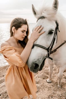 A white horse and a woman in a dress stand on a beach, with the sky and sea creating a picturesque backdrop for the scene