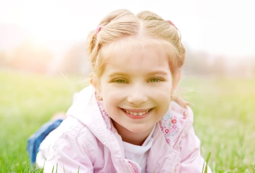 Cute little girl on the meadow in spring day