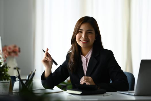 Gorgeous female entrepreneur in luxury suit working on sale marketing project at modern workplace.