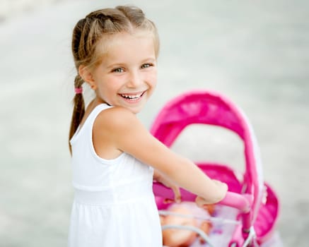 Cute little girl with her toy carriage