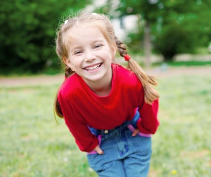 Cute little girl on the meadow in summer day