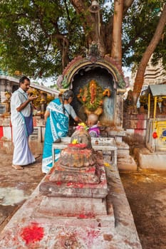 MADURAI, INDIA - FEBRUARY 16, 2013: Indian pilgrim family worshipping Hindu god Ganesh in famous Meenakshi Amman Temple - historic Hindu temple located in temple city Madurai