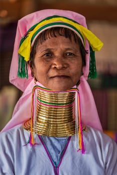 INLE LAKE, MYANMAR - JANUARY 7, 2014: Padaung long-necked tribe woman. The Padaung long-necked tribe women wear brass rings around neck from 5 years old and minority exploited for tourism reasons