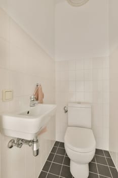 a white bathroom with black tile flooring and wall mounted toilet in the corner, there is a mirror above the sink