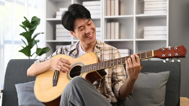 A man playing a guitar at home. Domestic life concept..