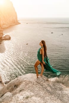 Woman sea trevel green dress. Side view a happy woman with long hair in a long mint dress posing on a beach with calm sea bokeh lights on sunny day. Girl on the nature on blue sky background