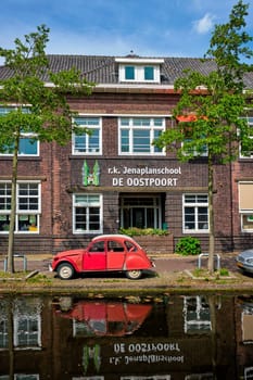 Delft, Netherlands - May 12, 2017: Retro vintage car Citroen 2CV in street of Delft near canal