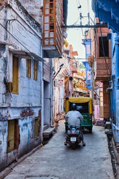 Jodhpur, India - November 13, 2019: Street traffic in indian street. Motorcycle and auto rickshaw are very common transportation options in India. Jodhpur, Rajasthan, India