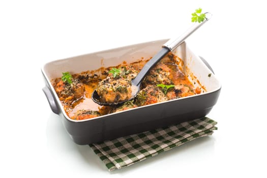 cooked minced meat meatballs in sauce in ceramic form, isolated on white background