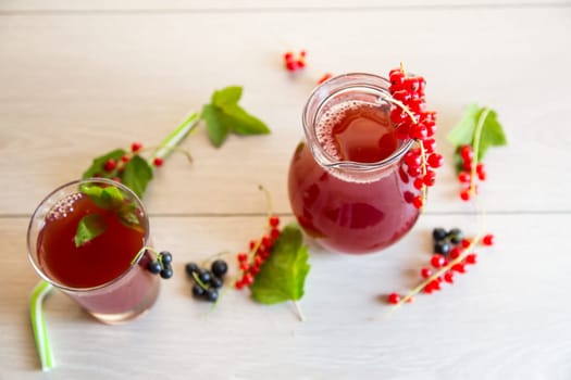 fresh berry juice from red and black currant, on a light wooden table