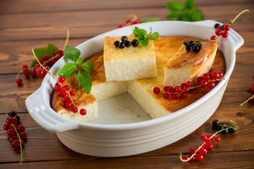 cottage cheese sweet casserole with fresh berries, on a wooden table