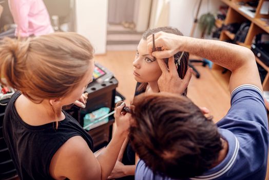 Makeup teacher helping students training to become makeup artist.