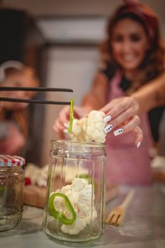 Happy young woman enjoy preparing for marinating cauliflower and making healthy meal at her home kitchen.  