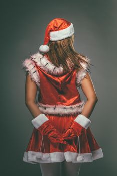 Rear view of a beautiful young woman in Santa Claus costume.