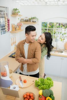 young asian couple cooking in kitchen