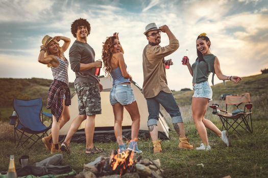 Happy young friends enjoy a nice day in nature. They're looking at camera, happy to be together.