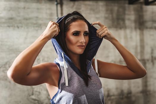 A cute young woman is resting after training at the gym. 