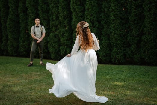 wedding walk of the bride and groom in a coniferous park in summer