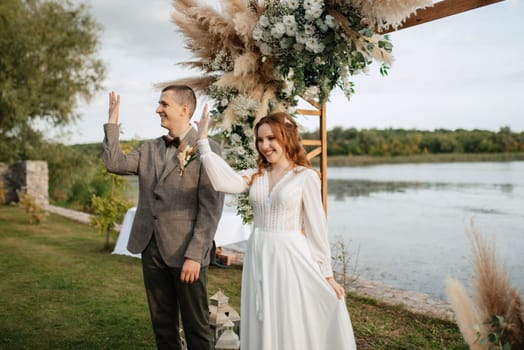 wedding ceremony of the newlyweds in a country cottage on a green hill