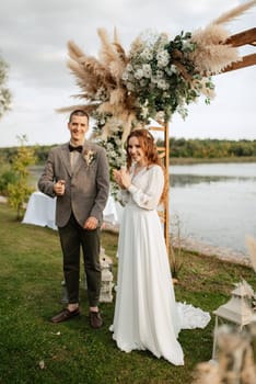 wedding ceremony of the newlyweds in a country cottage on a green hill