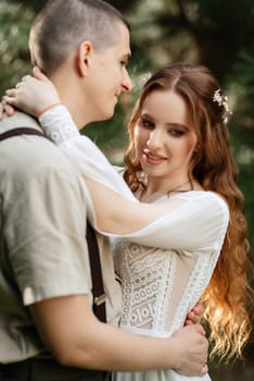 wedding walk of the bride and groom in a coniferous park in summer