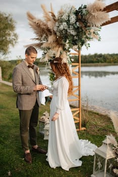 wedding ceremony of the newlyweds in a country cottage on a green hill