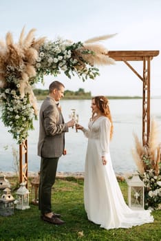 wedding ceremony of the newlyweds in a country cottage on a green hill