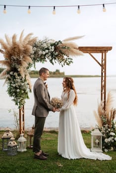 wedding ceremony of the newlyweds in a country cottage on a green hill