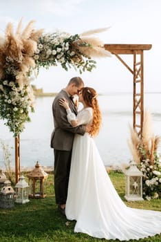 wedding ceremony of the newlyweds in a country cottage on a green hill