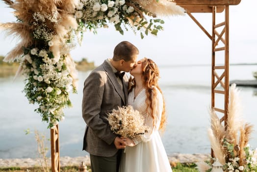 wedding ceremony of the newlyweds in a country cottage on a green hill