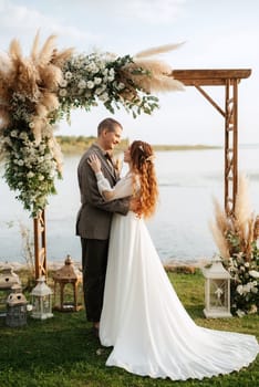 wedding ceremony of the newlyweds in a country cottage on a green hill