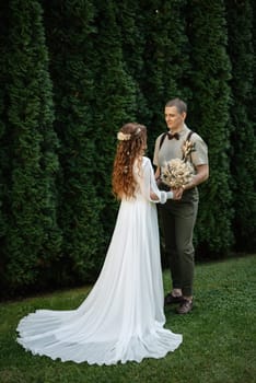 wedding walk of the bride and groom in a coniferous park in summer