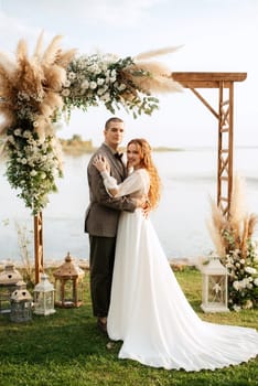 wedding ceremony of the newlyweds in a country cottage on a green hill