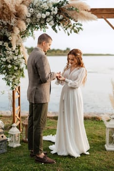 wedding ceremony of the newlyweds in a country cottage on a green hill