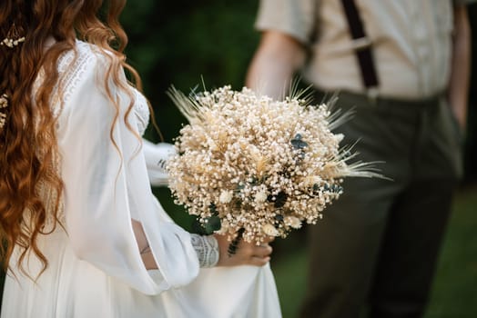 wedding walk of the bride and groom in a coniferous park in summer