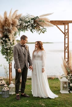 wedding ceremony of the newlyweds in a country cottage on a green hill