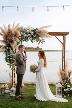 wedding ceremony of the newlyweds in a country cottage on a green hill