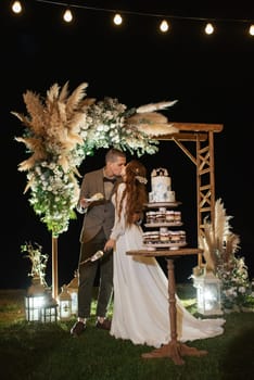 newlyweds happily cut, laugh and taste the wedding cake