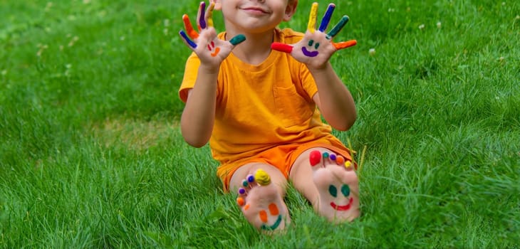 a smile painted with paints on the child's arms and legs. Selective focus