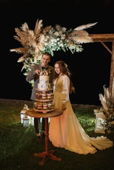 newlyweds happily cut, laugh and taste the wedding cake