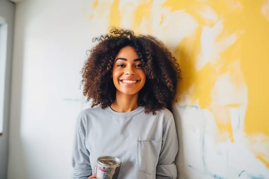 Happy African American woman painting a wall. Repair concept. High quality photo