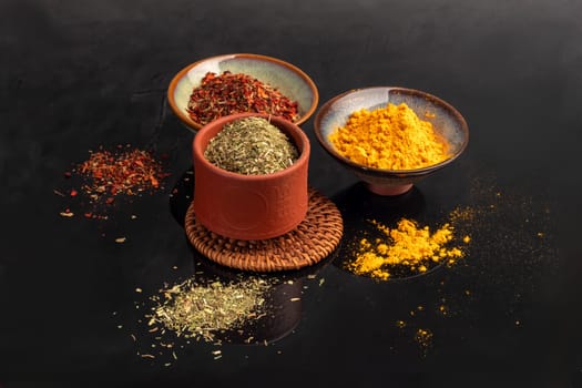 Variety of spices on a dark background in a glass bowl. Enhancement of taste. copy space