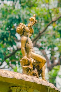 Golden boy statue on the fountain in the park