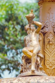 Golden boy statue on the fountain in the park