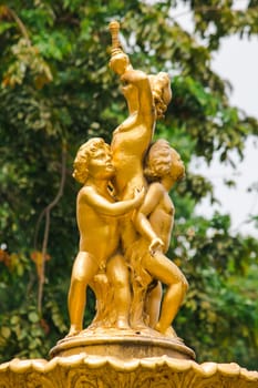 Golden boy statue on the fountain in the park